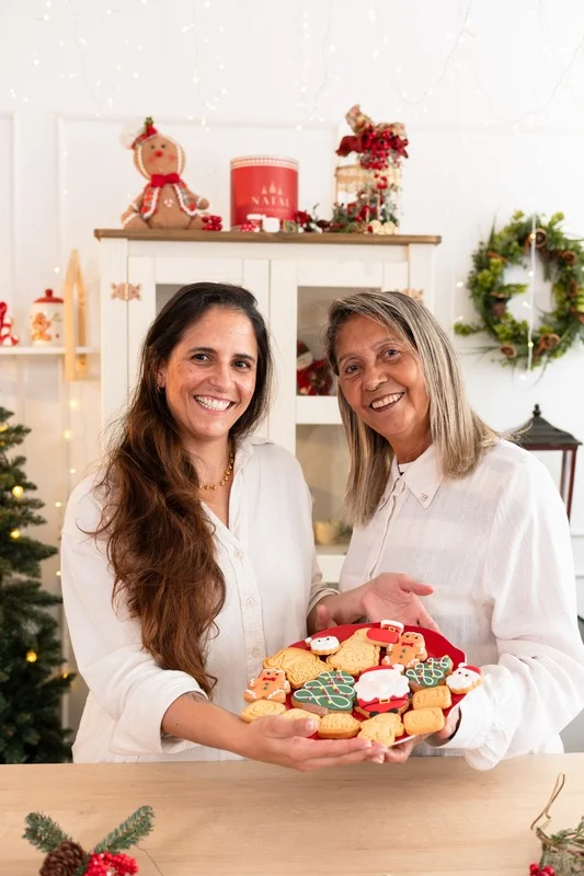 Bia e Luzinete juntas, segurando uma travessa de biscoitos decorados reais