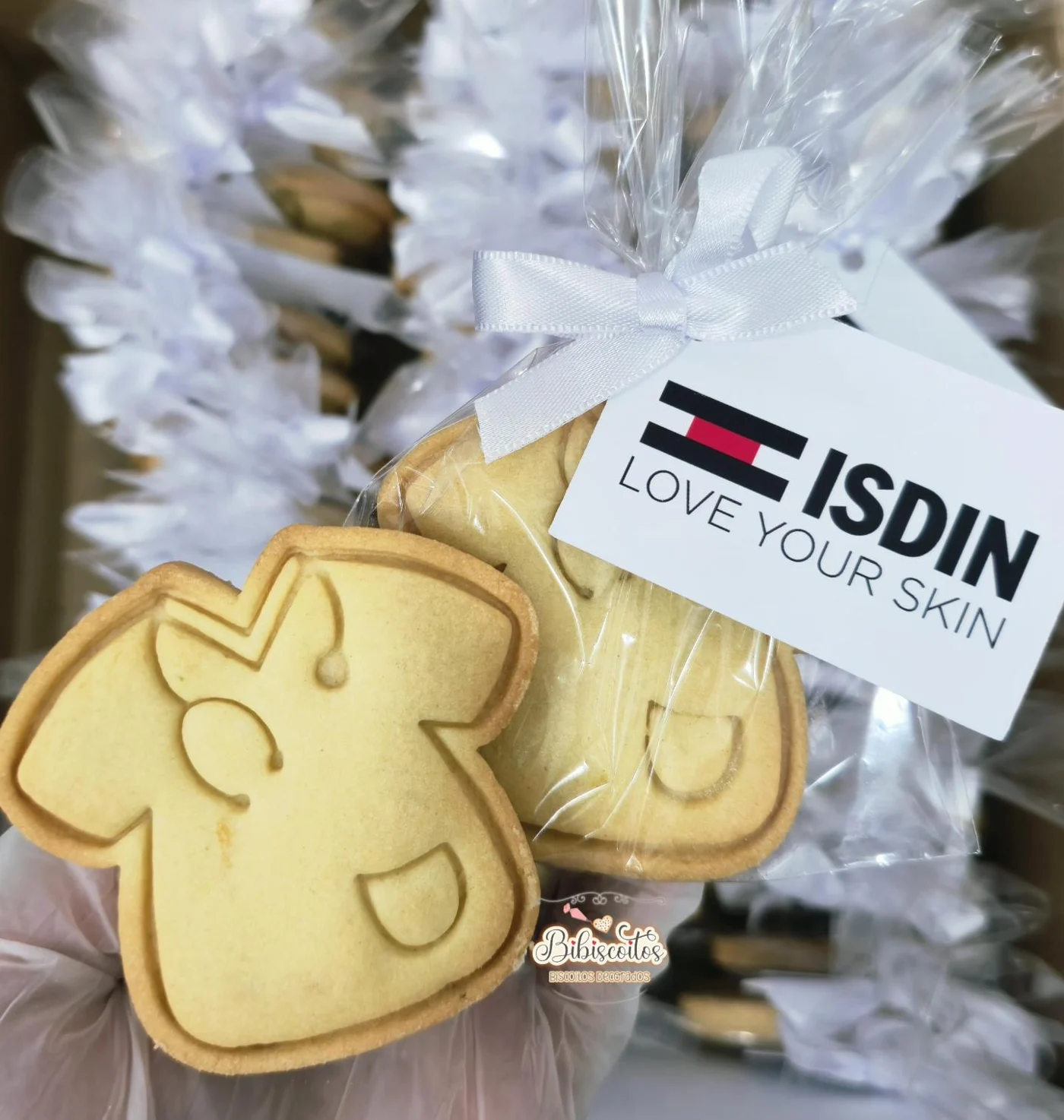 Biscoitos personalizados para a ISDIN com tag e laço brancos